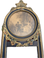 Antique oval-topped decorative mirror with an inset print and ornate frame.