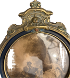 Antique oval-topped decorative mirror with an inset print and ornate frame.